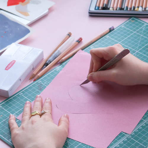 Cutting a heart out of pink paper