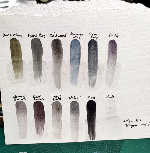 Paint swatches of tinted charcoal paint pan set on textured off-white paper