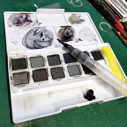 Mini waterbrush shown with tinted charcoal paint pan set