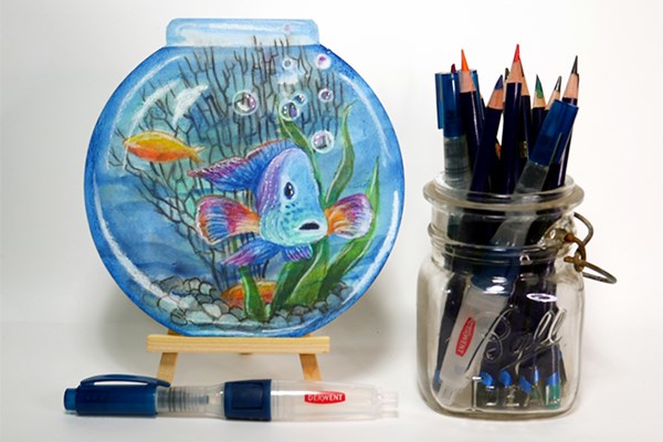 Fishbowl drawing on an easel next to Inktense pencils in a mason jar