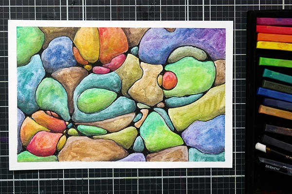 Colourful artwork next to Derwent Inktense blocks